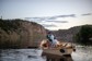 Angler fights a fish from a boat on the Gunnison River.